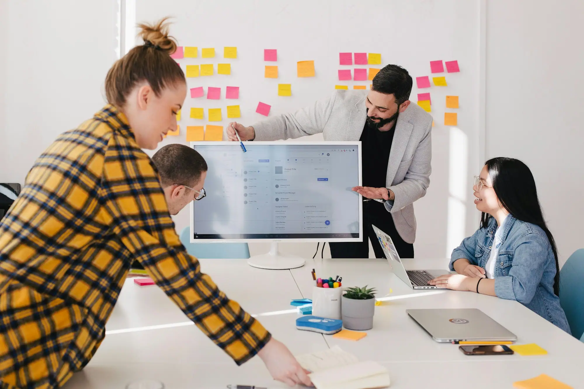 Equipo de profesionales de marketing colaborando frente a una pantalla en una oficina moderna y luminosa