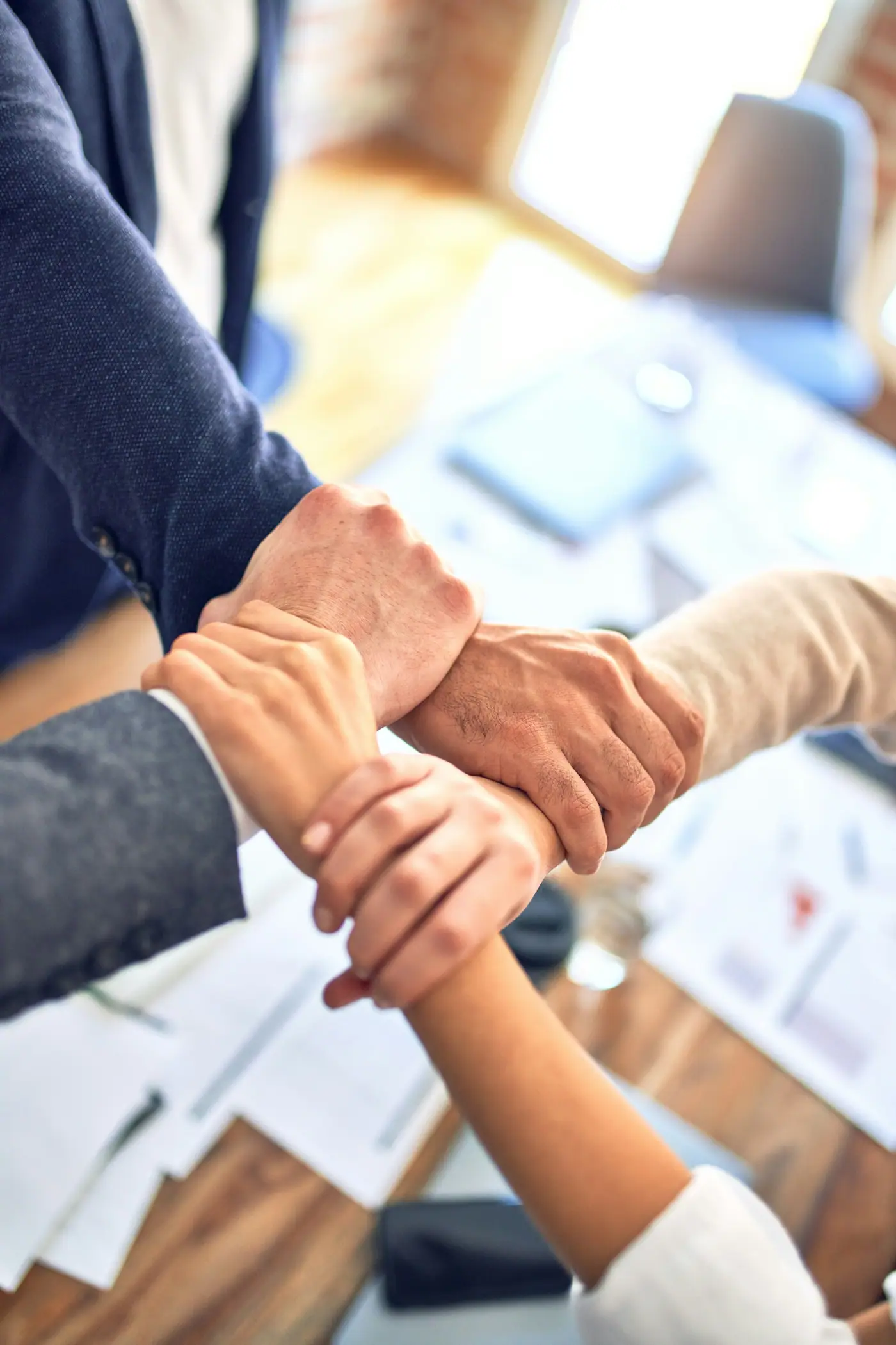 Manos de varias personas unidas en señal de trabajo en equipo