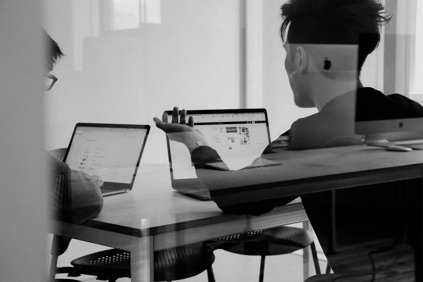 Equipo reunido alrededor de una mesa analizando información en sus laptops