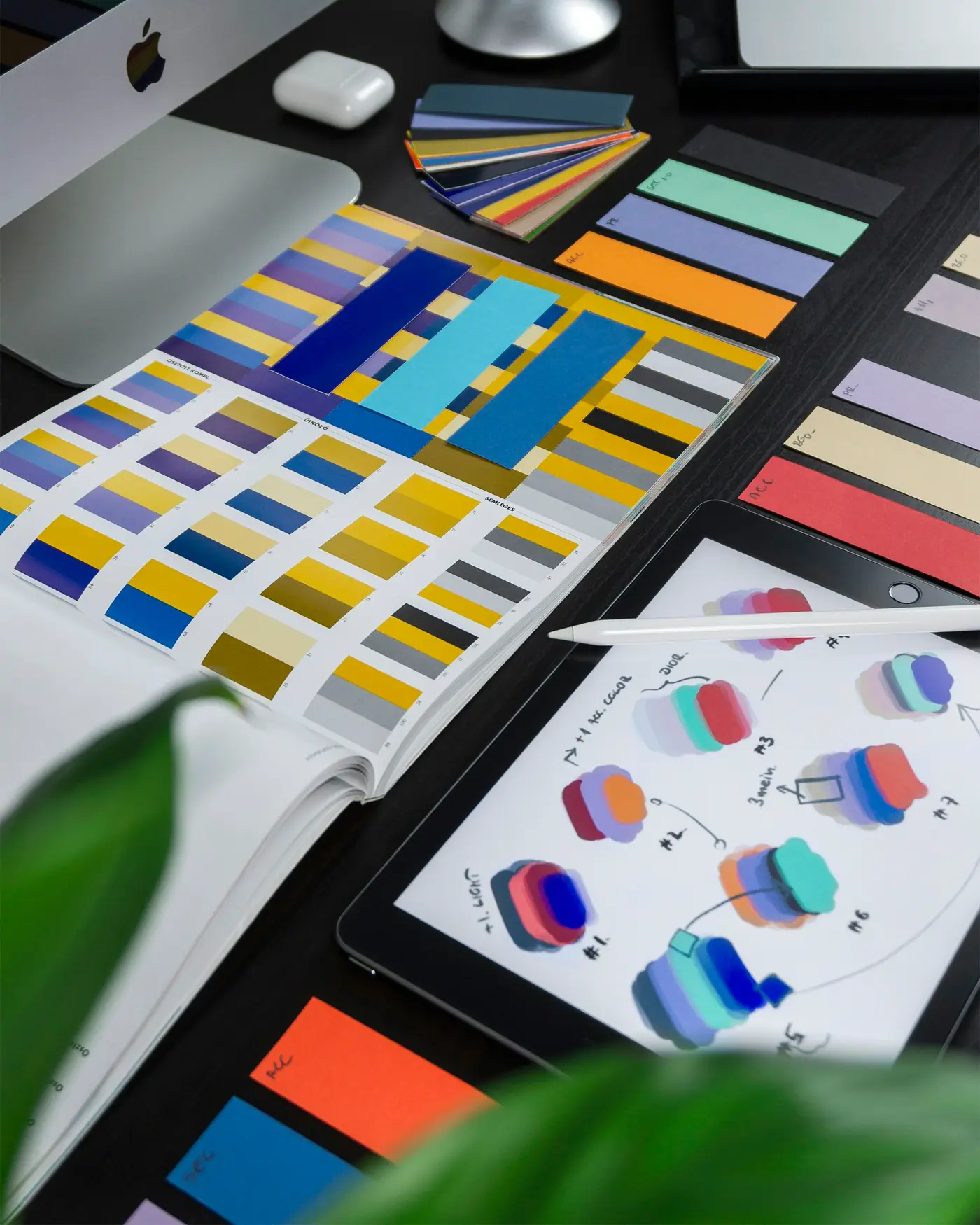 Muestras de color y bocetos de identidad visual sobre una mesa de diseño