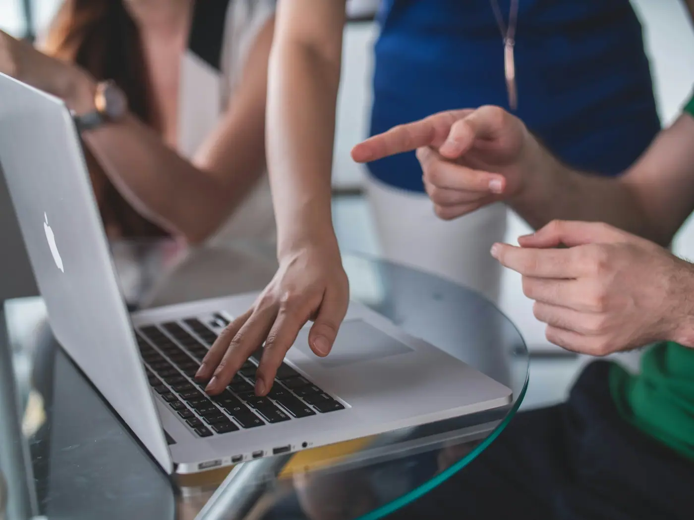 Dos personas señalando información en la pantalla de una laptop durante una revisión